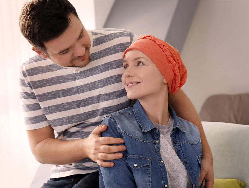 young man comforting his wife with cancer