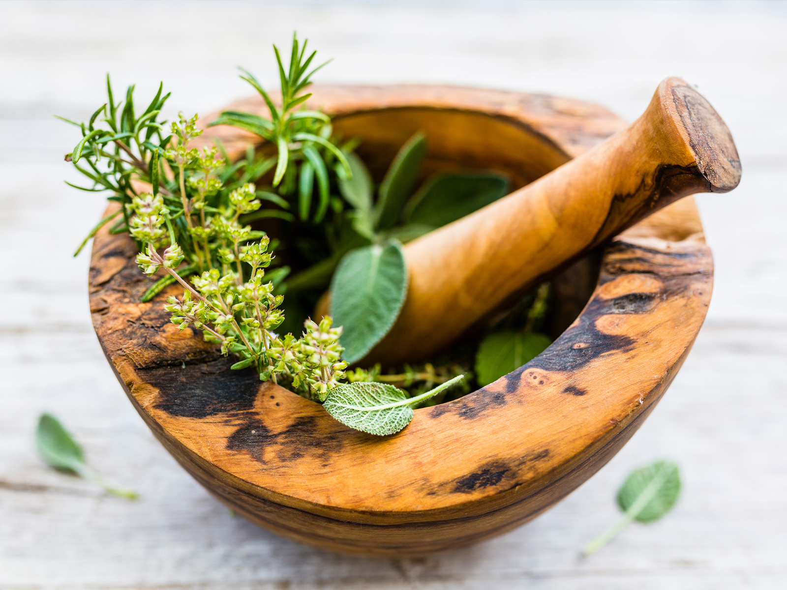 wooden mortar & pestle with fresh herbs