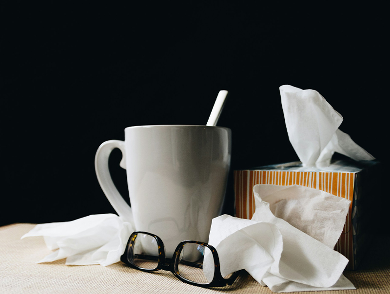 mug, tissues, glasses, giving the impression of sickness