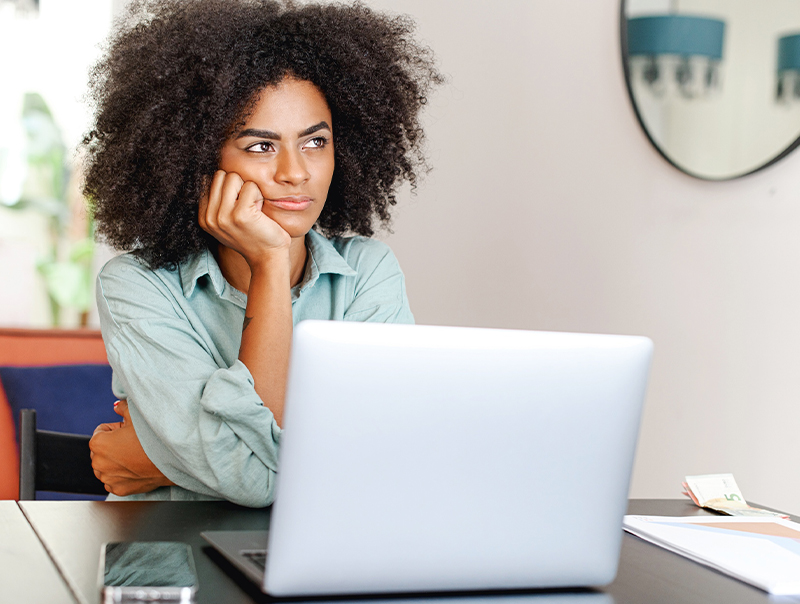 unfocused woman sitting by her laptop