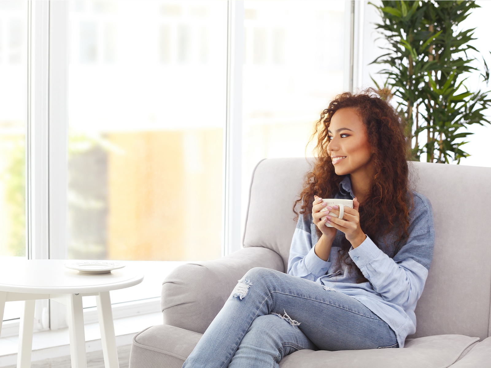 woman sitting on couch with a hot drink