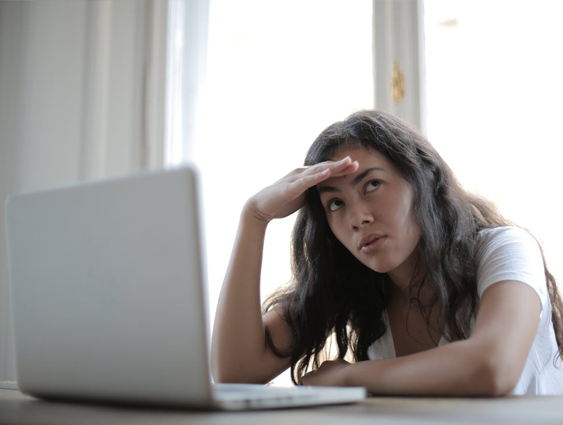 young lady with laptop looking stresses