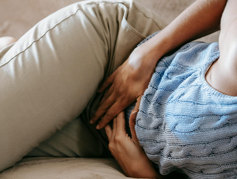 woman laying on the couch holding her belly